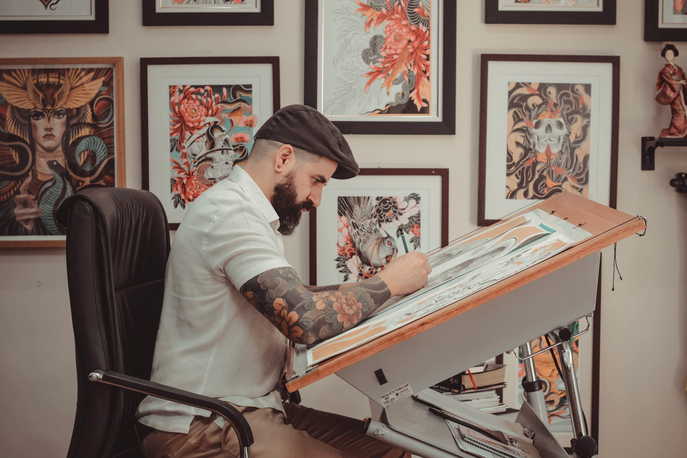 Denis Vazios desenhando na prancheta, cercado por suas obras